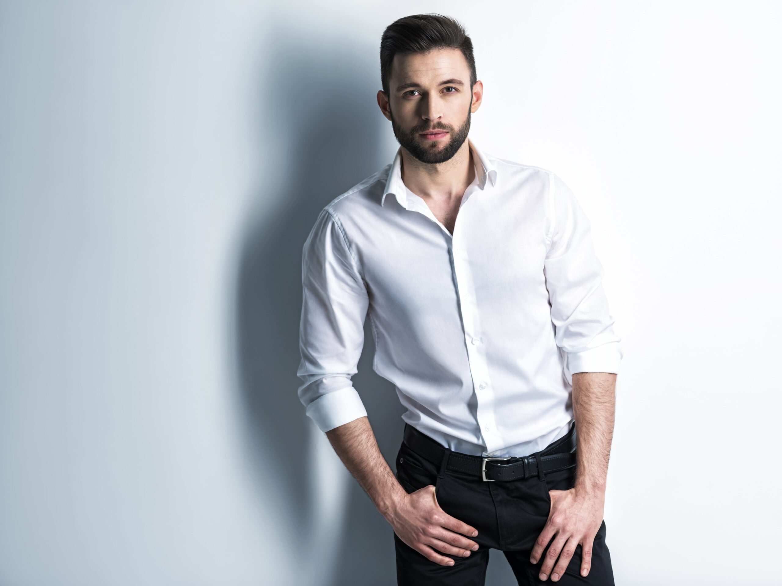 handsome-man-white-shirt-black-trousers-posing-attractive-guy-with-fashion-hairstyle-confident-man-with-short-beard-adult-stylish-boy-with-brown-hair-min